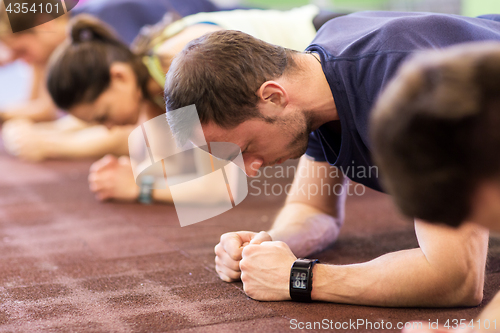 Image of man with heart-rate tracker exercising in gym