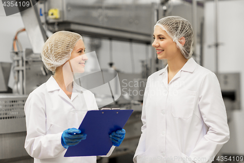 Image of happy women technologists at ice cream factory