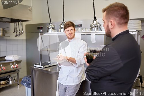 Image of happy smiling chef and cook at restaurant kitchen