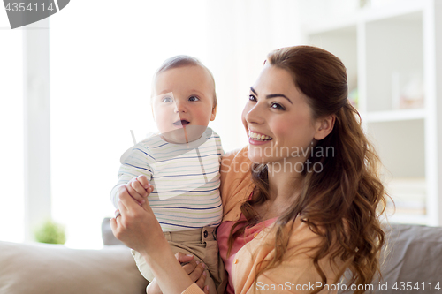 Image of happy young mother with little baby at home