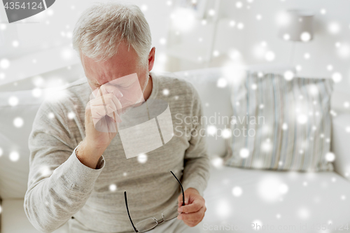 Image of senior man suffering from headache at home