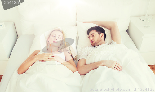 Image of happy couple sleeping in bed at home