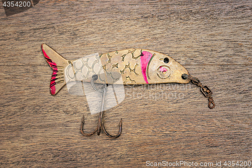 Image of Retro rusty lure on the wooden background