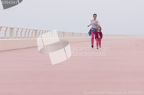 Image of mother and cute little girl on the promenade by the sea