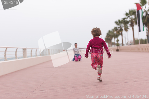 Image of mother and cute little girl on the promenade by the sea