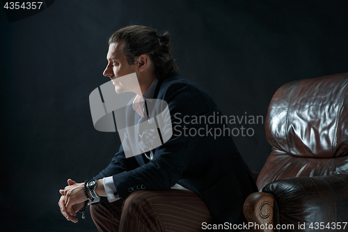 Image of Businessman sitting on an armchair