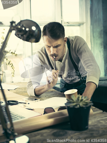 Image of Architect working on drawing table in office