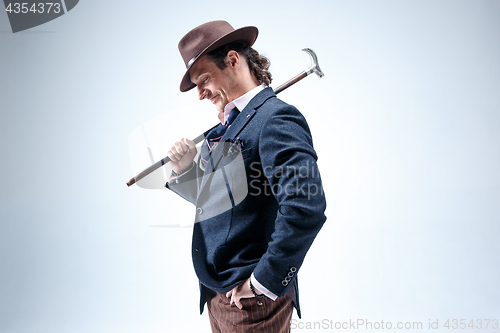 Image of Young man portrait with hat on gray studio background.