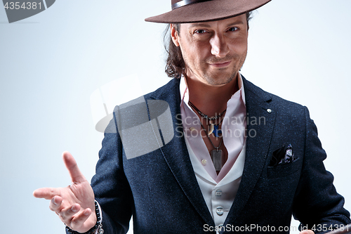 Image of Young man portrait with hat on gray studio background.