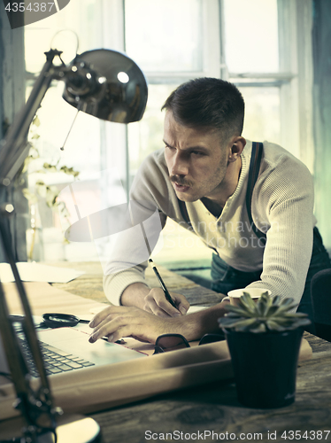 Image of Architect working on drawing table in office