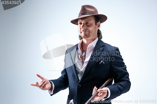 Image of Young man portrait with hat on gray studio background.