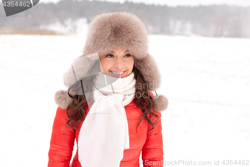 Image of happy woman in winter fur hat outdoors