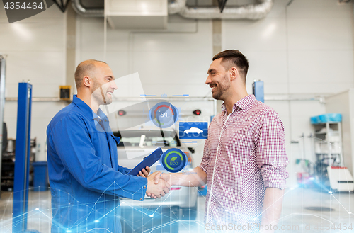 Image of auto mechanic and man shaking hands at car shop