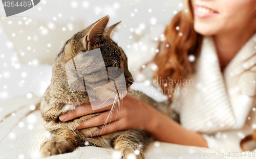 Image of close up of cat and woman in bed