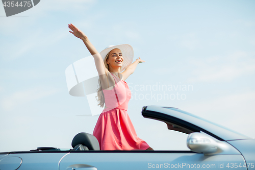 Image of happy young woman in convertible car