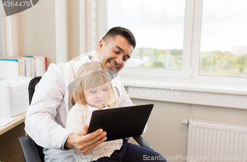 Image of doctor and little girl with tablet pc at clinic