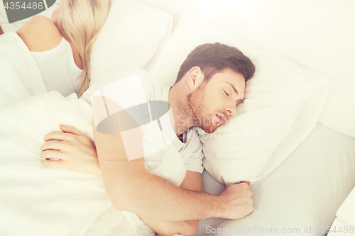 Image of couple sleeping in bed at home