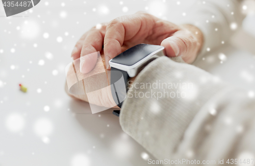 Image of close up of old man hand with pill and smart watch