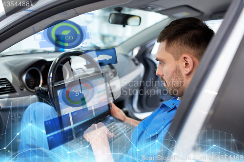 Image of mechanic man with laptop making car diagnostic