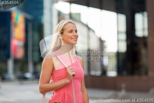 Image of happy smiling young woman on city street