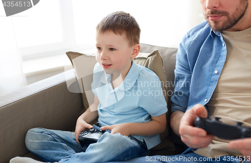 Image of father and son playing video game at home