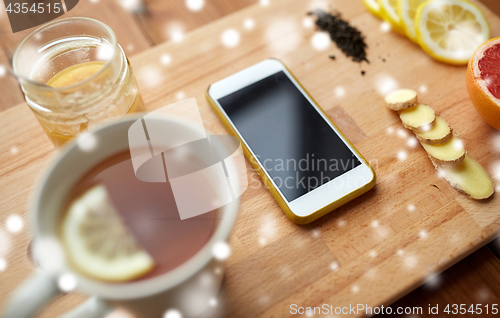 Image of smartphone with cup of lemon tea, honey and ginger