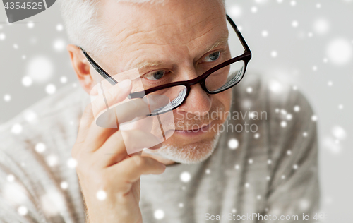 Image of close up of senior man in glasses thinking