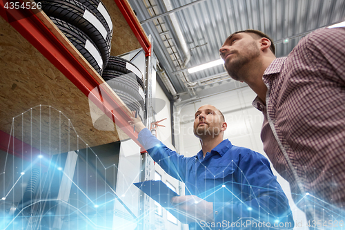 Image of auto mechanic and man with tires at car shop