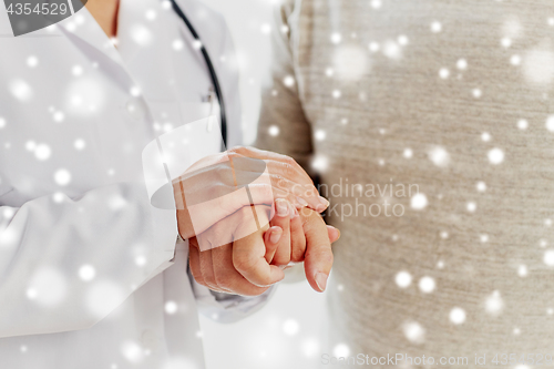 Image of close up of doctor holding old man hand