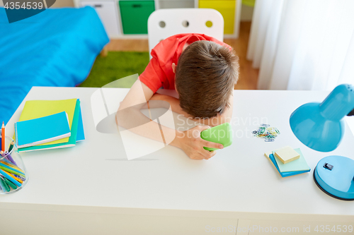 Image of tired or sad student boy with smartphone at home