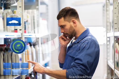 Image of auto mechanic with clipboard at car workshop