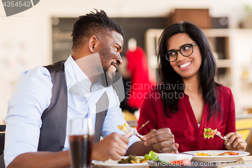 Image of happy couple eating at restaurant