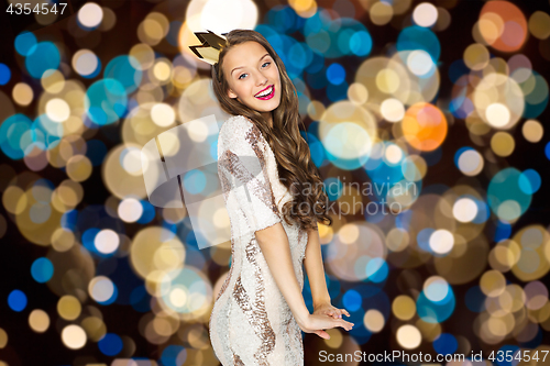 Image of happy young woman in crown over festive lights