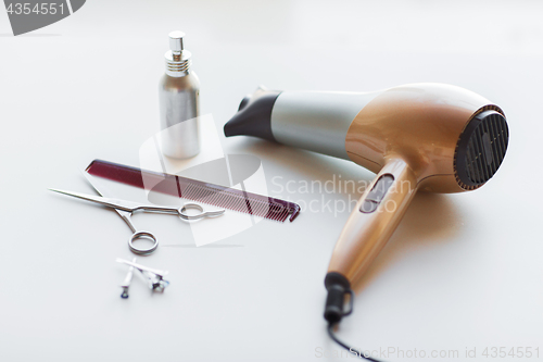 Image of hairdryer, scissors, comb and styling hair spray