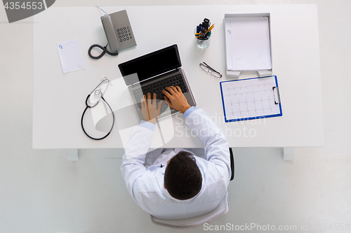 Image of doctor with cardiogram and laptop at clinic