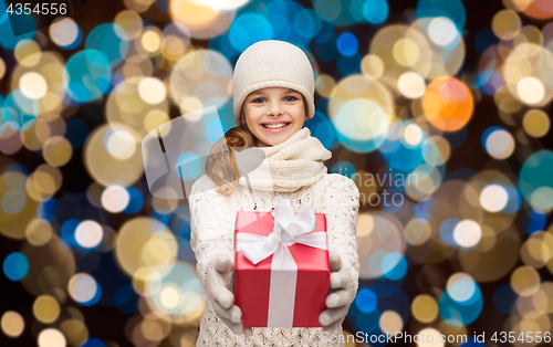 Image of happy girl in winter clothes with gift box