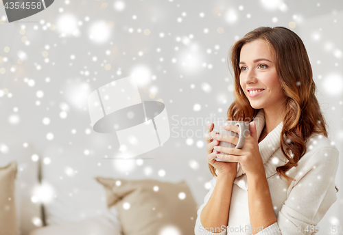 Image of happy woman with cup of coffee or tea at home