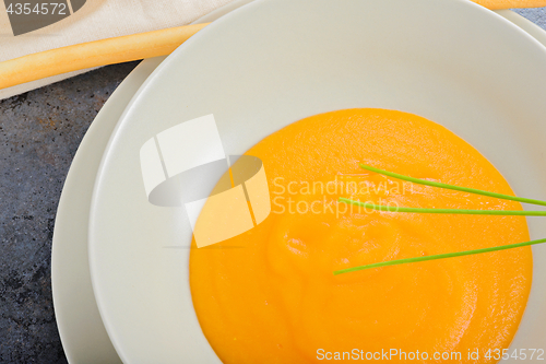 Image of Orange pumpkin cream soup and green onion