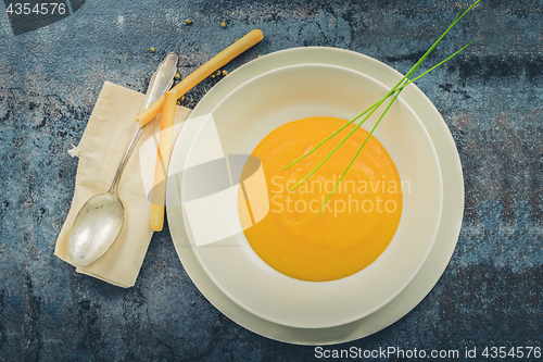 Image of Delicious healthy pumpkin soup, spoon and napkin