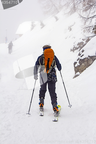 Image of Man with skis walk by snow on the mountain