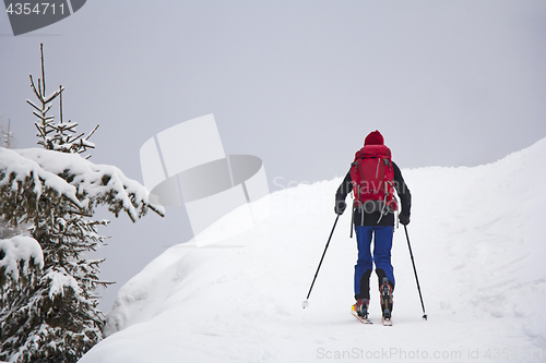 Image of Man with skis walk by snow on the mountain