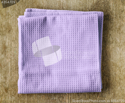 Image of violet towel on wooden table