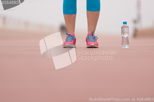 Image of close up on running shoes and bottle of water