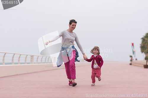 Image of mother and cute little girl on the promenade by the sea