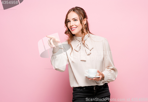 Image of The serious frustrated young beautiful business woman on pink background