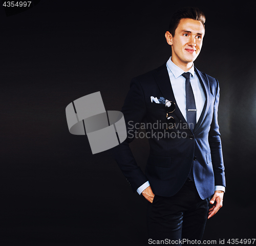 Image of young pretty business man standing on black background, modern h