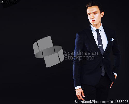 Image of young pretty business man standing on black background, modern h