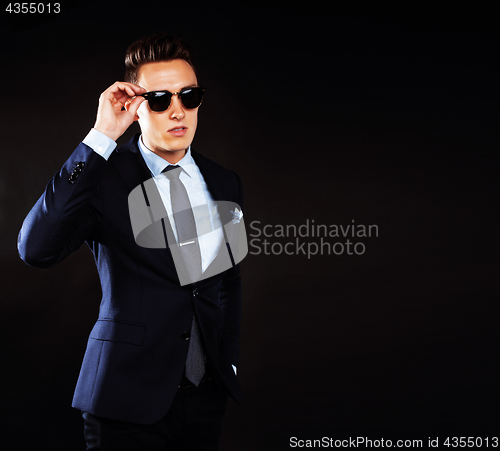 Image of young pretty business man standing on black background, modern h