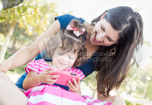 Image of Mixed Race Mother and Cute Baby Daughter Playing with Cell Phone