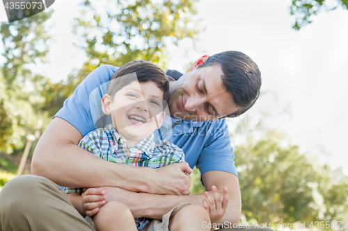 Image of Loving Young Father Tickling Son in the Park.